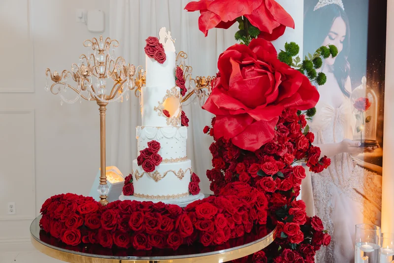 Tiered cake framed by cascading red roses